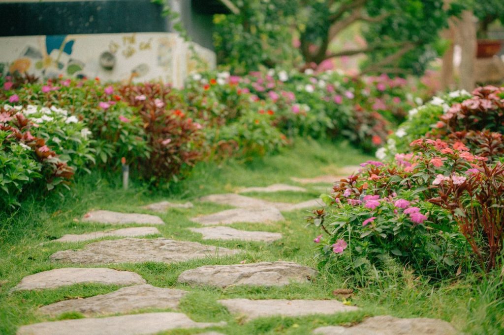 Een tuinpad met bloemen en groene borders